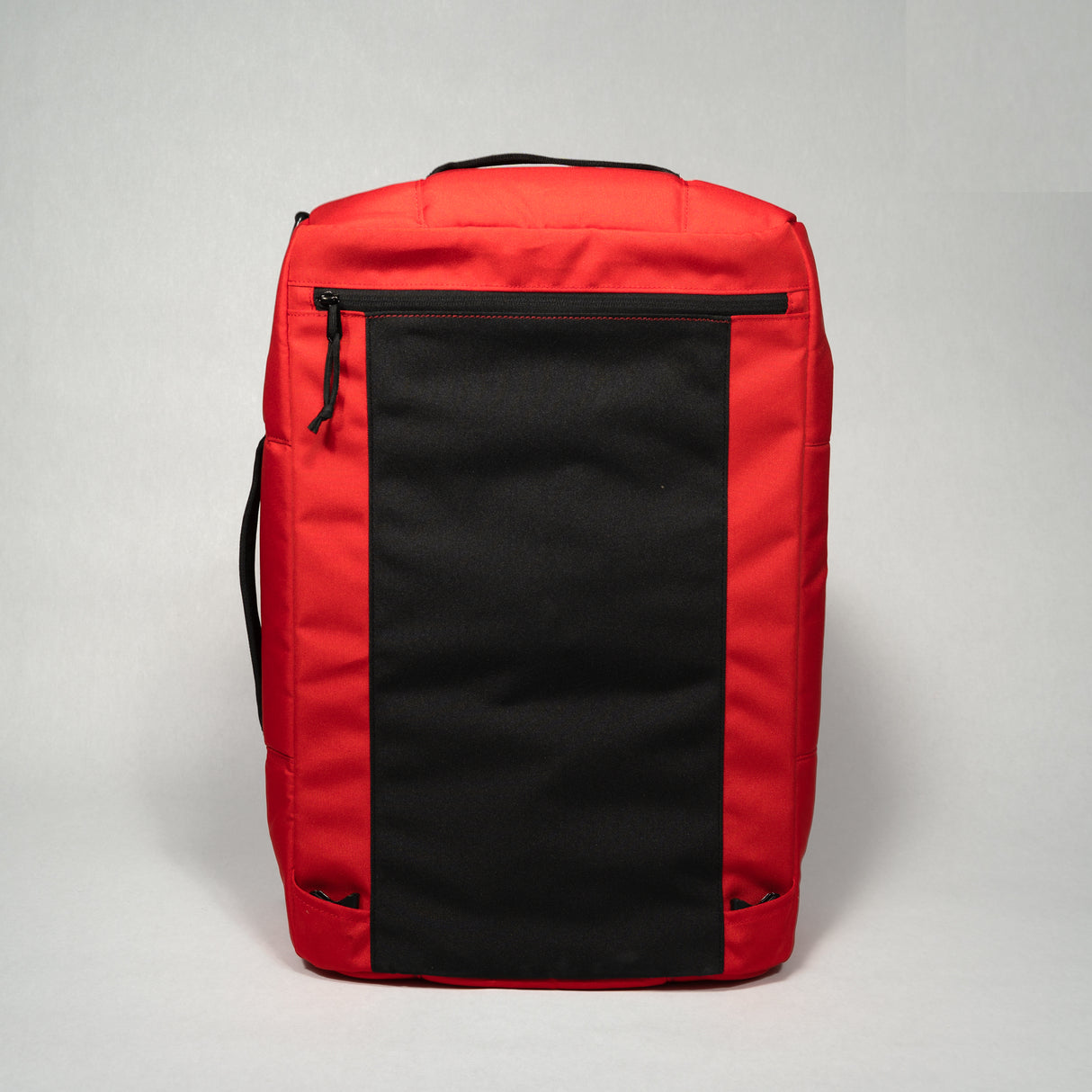 Red and black duffle bag with a large front pocket, zipper closure, and padded handle on a plain background.