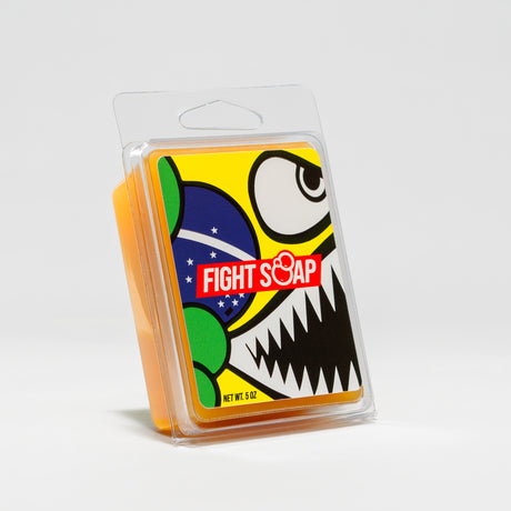 Colorful soap packaging featuring a cartoon skull with bold black teeth, large eye, and a Brazilian flag design.