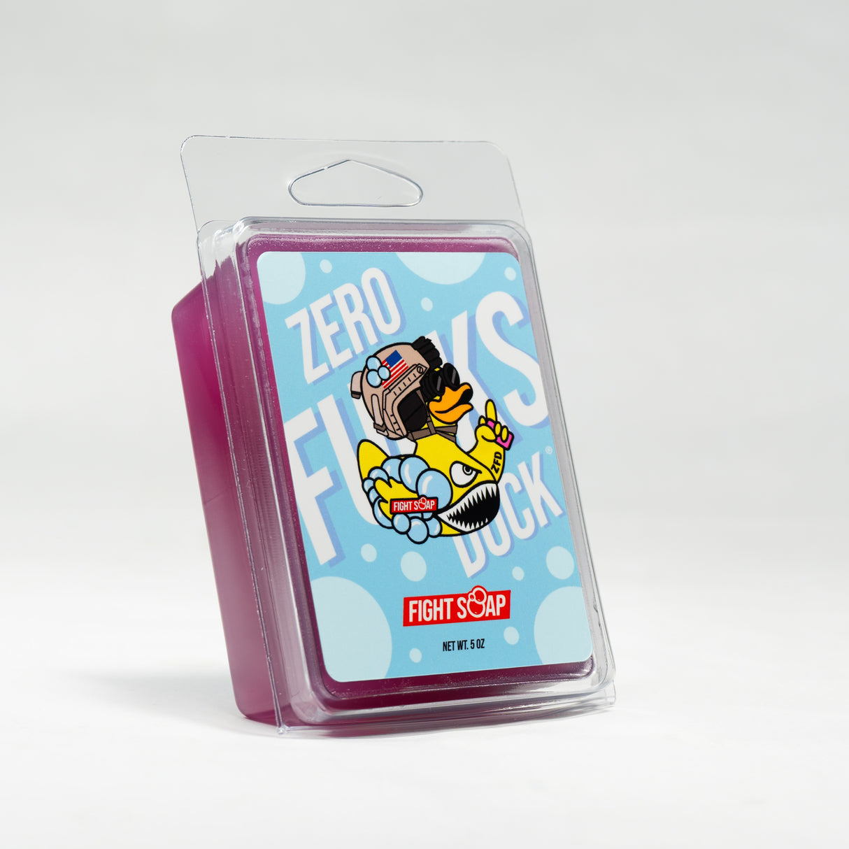 A pink soap bar in clear plastic packaging featuring a cartoon duck with a backpack, goggles, and a peace sign, labeled "Zero Fucks Duck®.